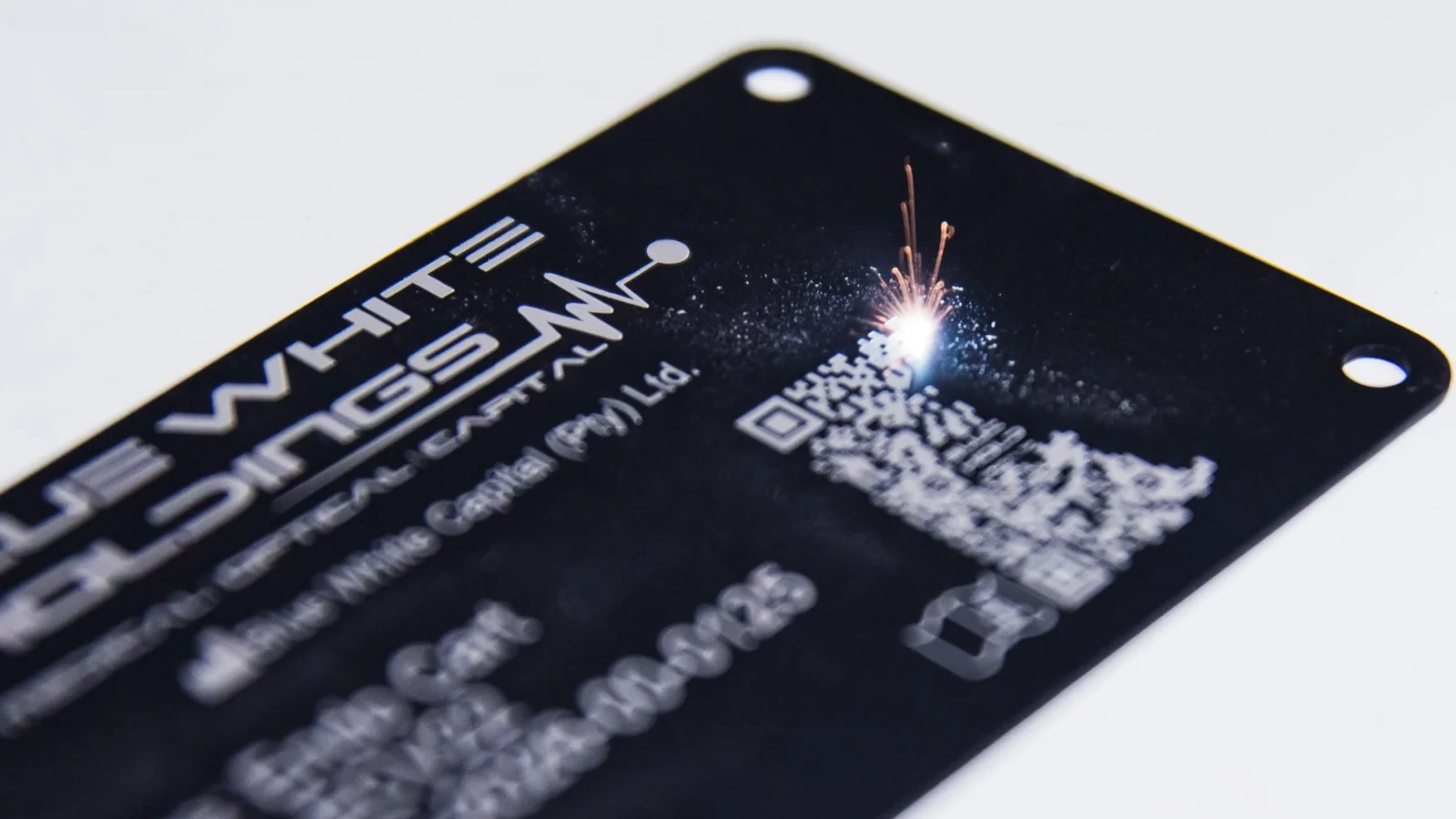 Laser-engraved Blue White Medical manufacturer label on a black metal plate