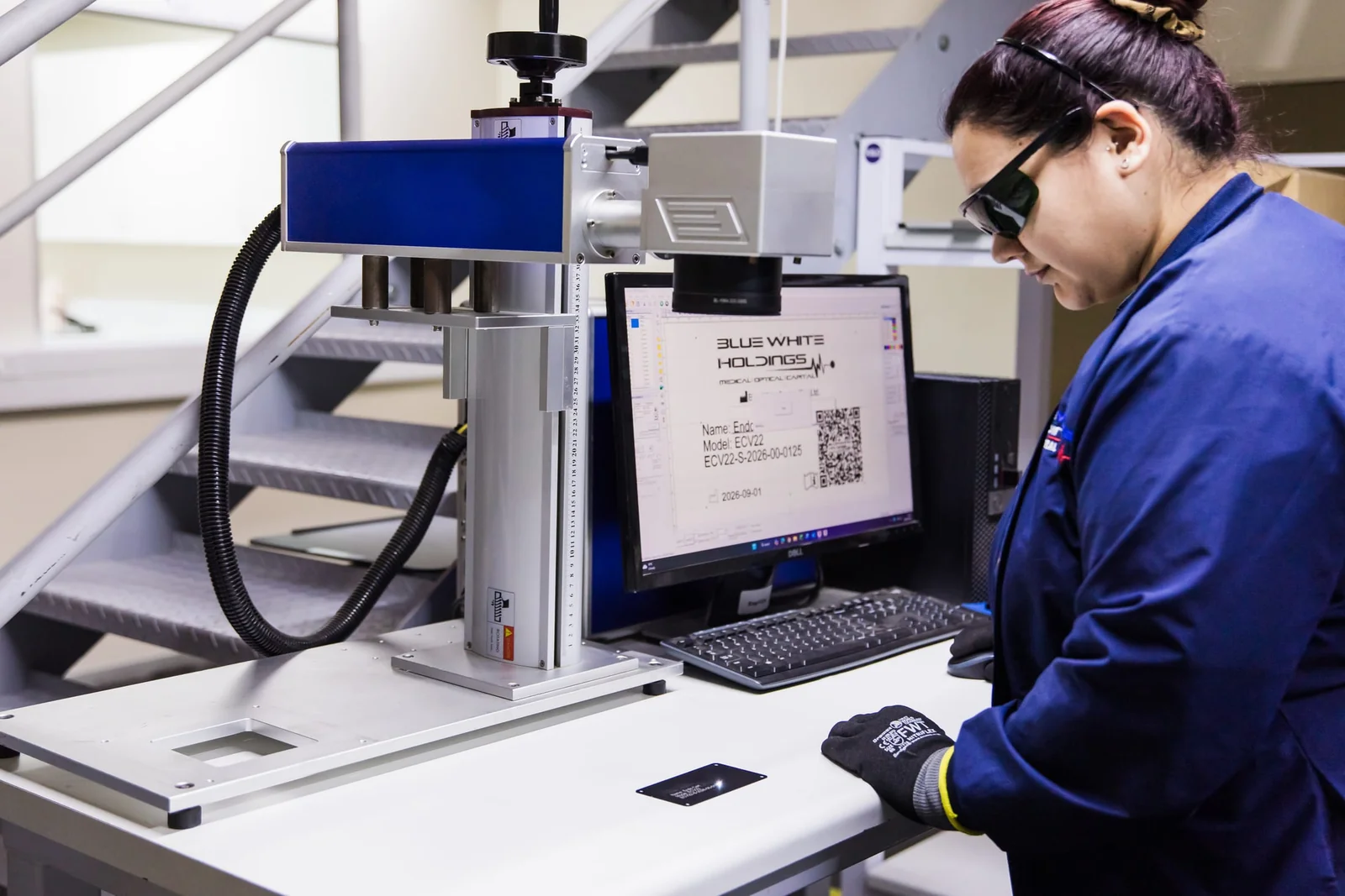 Blue White Medical technician operating the laser engraving station in the Pretoria workshop