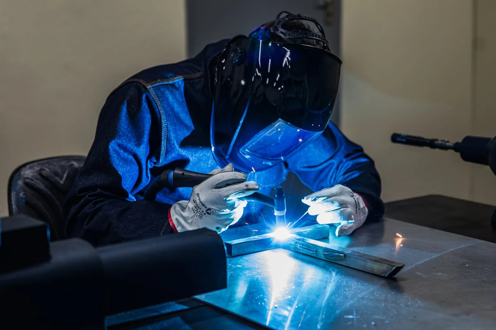 Blue White Medical technician welding a stainless-steel frame in the Pretoria workshop