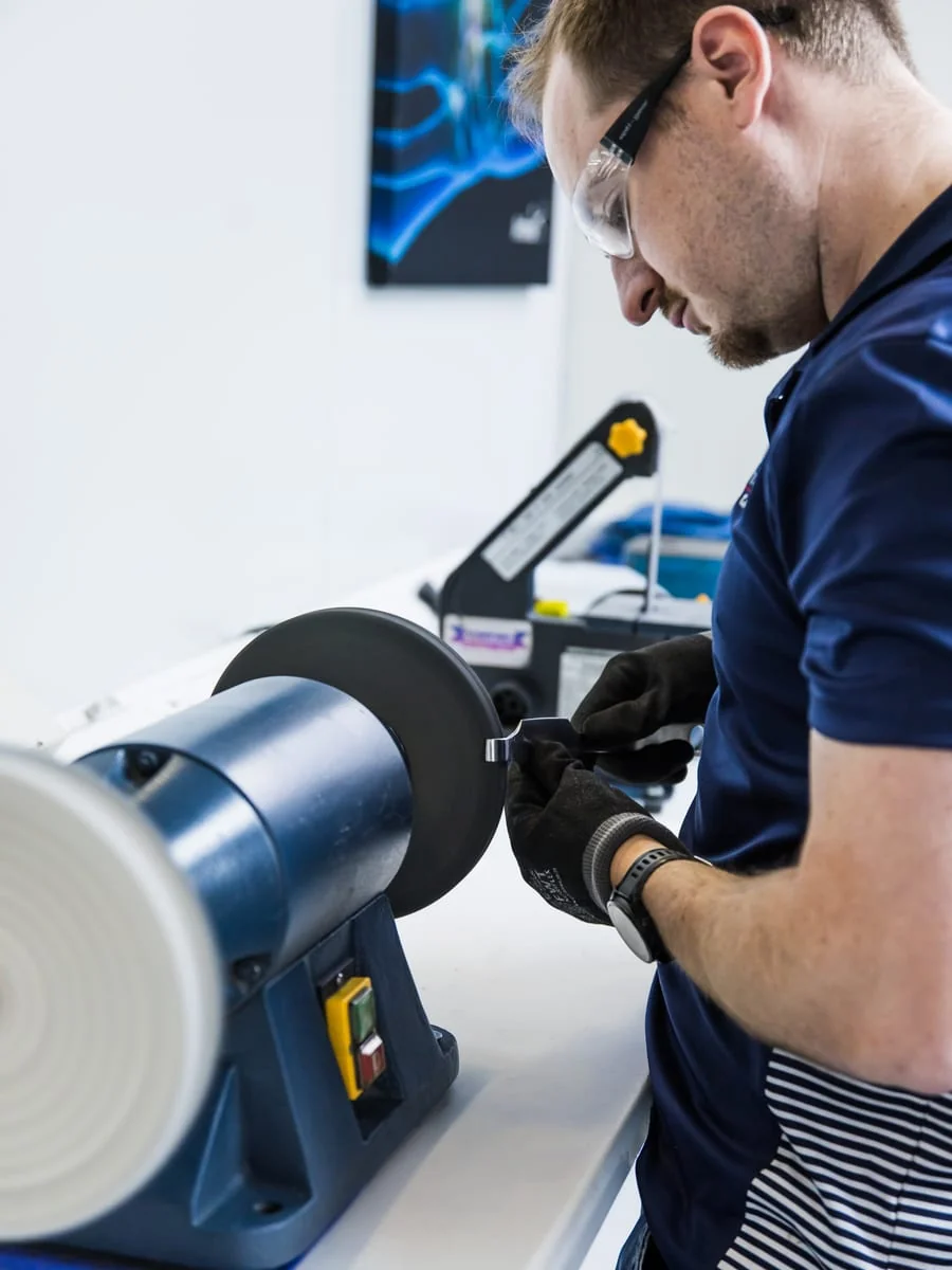 Blue White Medical technician polishing a surgical instrument in the Pretoria workshop