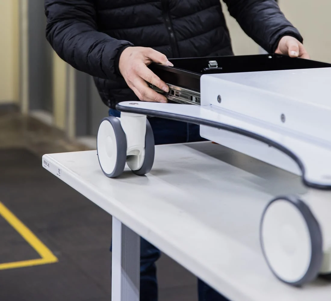 Blue White Medical technician assembling a theatre cart on its castors